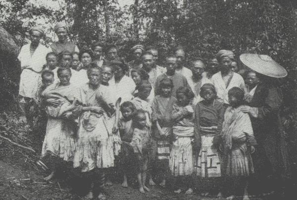 FAR FROM THE MADDENING THRONG

Regimenting the whole village to bid a sad farewell; Samuel Pollard,
author's traveling companion on this trip in the wilds, stands under the
hat on the right.