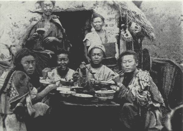 A REAL ABORIGINAL FEAST

The man on the left scowled in anger as the Author snapped his
picture—otherwise, all were happy. For them an exceptional feast, not an
everyday affair.