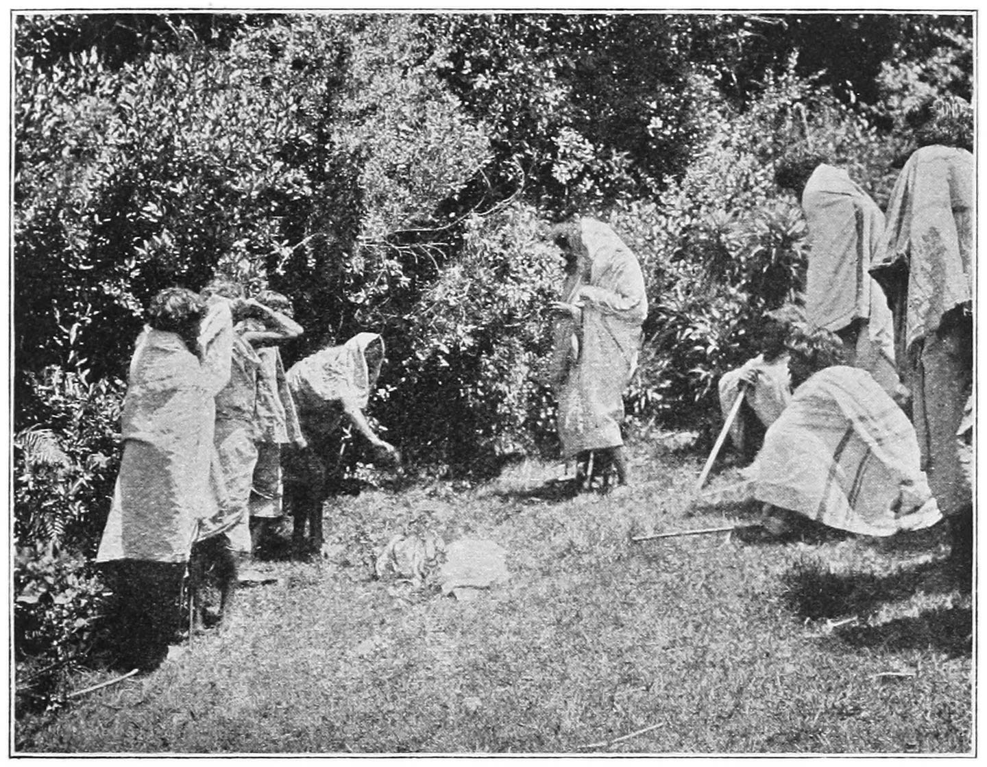 FIG. 50.—THE ‘PUZHUTPIMI’ CEREMONY. THROWING EARTH BACKWARDS ON THE CORPSE.