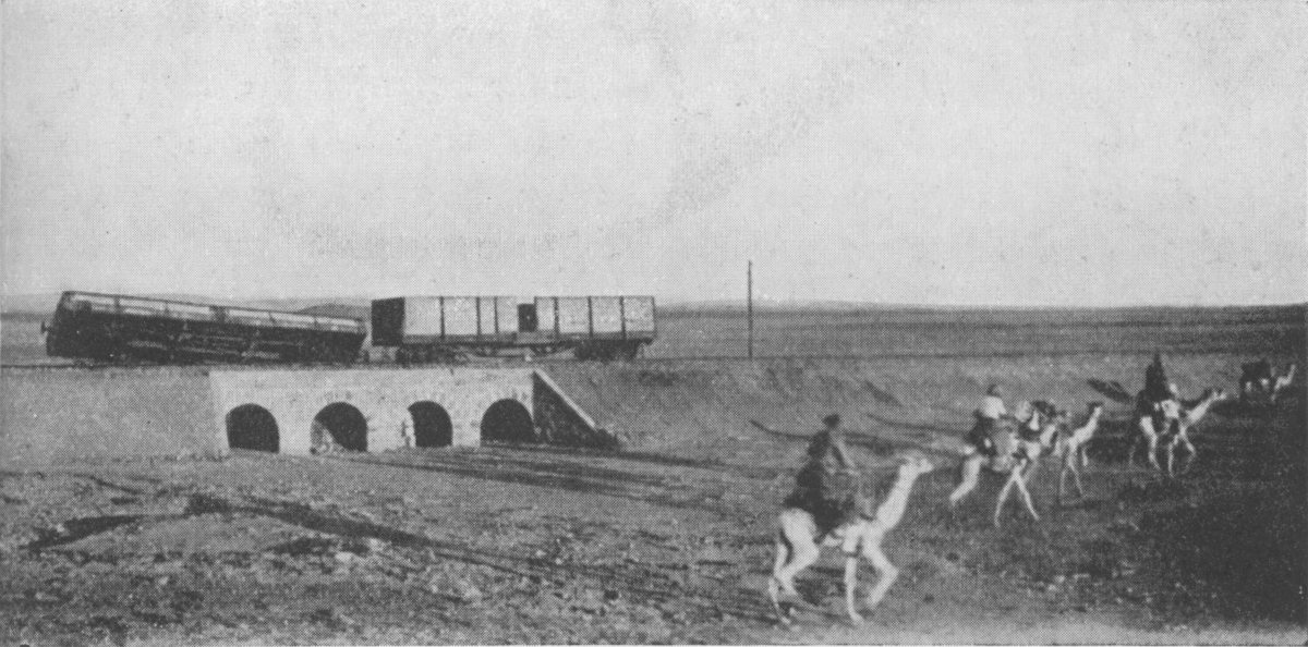 Photo wide shot of a toppled rail car over a bridge