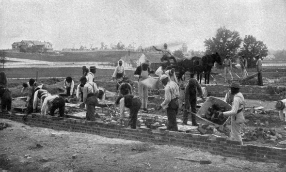 STARTING A NEW BUILDING.

Student masons laying the foundation in brick.