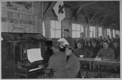 TICKLING THE OLD IVORIES
Many an ancient piano did herculean service in the A. R. C. recreation huts throughout France